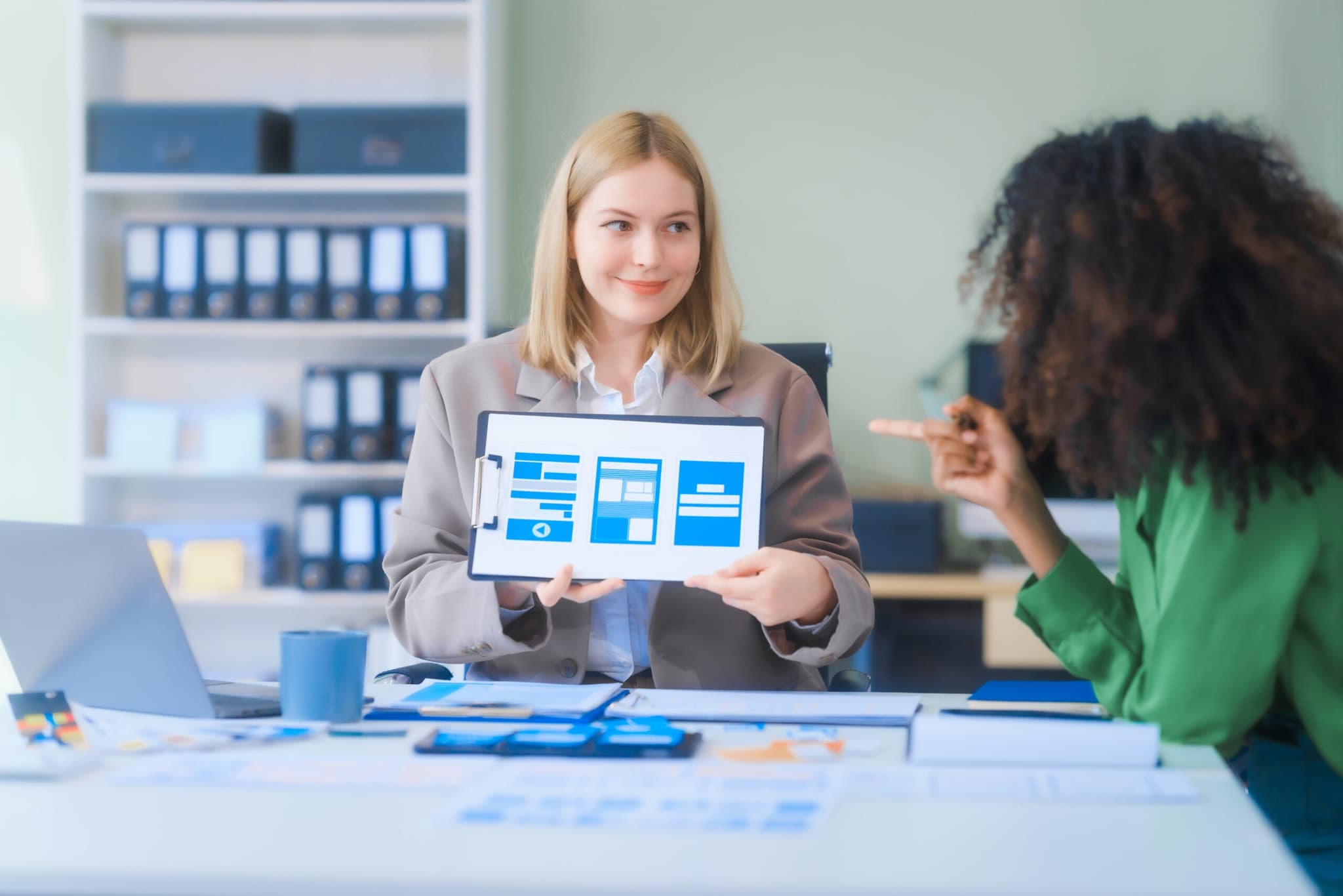Two people reviewing a tablet in an office